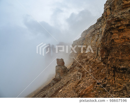 Ghost rocks. Awesome scenic mountain landscape with big cracked pointed stones closeup in misty morning. Sharp rocks background. 98607596