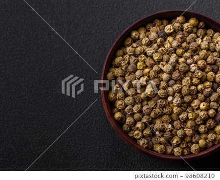 Spice, allspice green in a wooden bowl on a black concrete background Spice, allspice green in a wooden bowl on a black concrete background 98608210