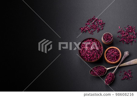 Dried beets in small slices in a wooden bowl on a black concrete background 98608216
