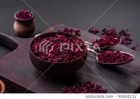 Dried beets in small slices in a wooden bowl on a black concrete background Dried beets in small slices in a wooden bowl on a black concrete background 98608232