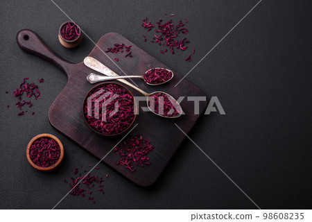 Dried beets in small slices in a wooden bowl on a black concrete background Dried beets in small slices in a wooden bowl on a black concrete background 98608235