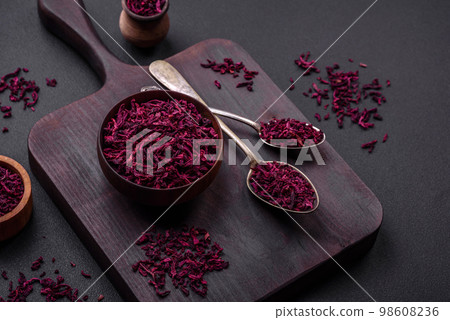 Dried beets in small slices in a wooden bowl on a black concrete background 98608236