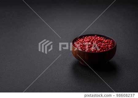 Spice, allspice peas of red or pink color in a wooden bowl Spice, allspice peas of red or pink color in a wooden bowl 98608237