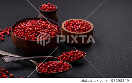 Spice, allspice peas of red or pink color in a wooden bowl 98608249