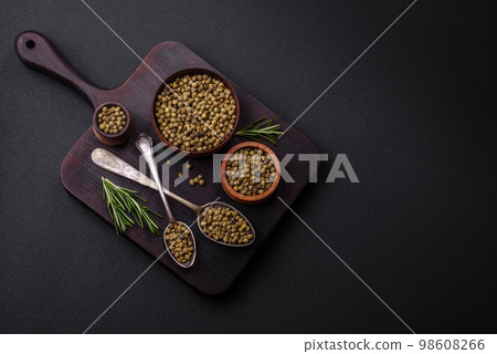 Spice, allspice green in a wooden bowl on a black concrete background 98608266