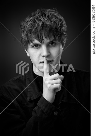 handsome man asking to be quiet with finger on lips. handsome man asking to be quiet with finger on lips. 98608594