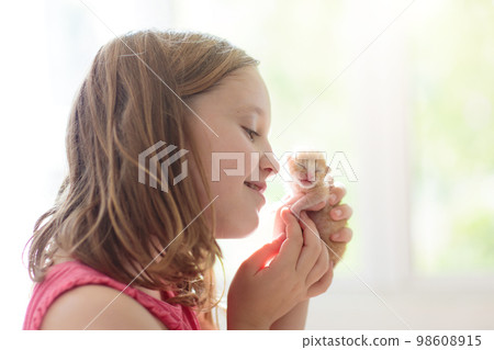 Little child holding baby cat. Kids and pets 98608915