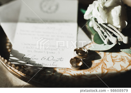Beautiful toned picture with wedding rings against the background of a bouquet of flowers Beautiful toned picture with wedding rings against the background of a bouquet of flowers 98608979