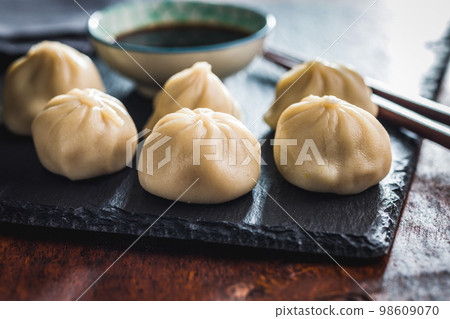 Xiaolongbao, traditional steamed dumplings. Xiao Long Bao buns on cutting board. 98609070
