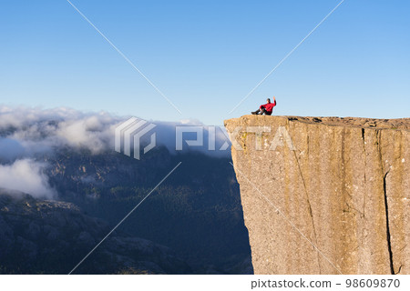 Guy on the Rock Preikestolen, Norway Guy on the Rock Preikestolen, Norway 98609870