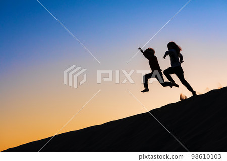 Kids silhouette at sunset sky background 98610103