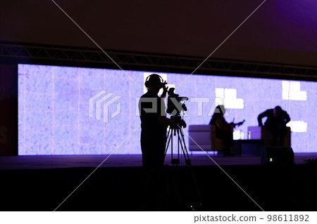 Silhouettes of people - the cameraman records the interview on camera Silhouettes of people - the cameraman records the interview on camera 98611892