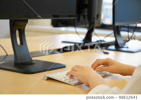 通過敲擊鍵盤、案頭工作圖像執行輸入工作的人的手 通過敲擊鍵盤、案頭工作圖像執行輸入工作的人的手 98612641
