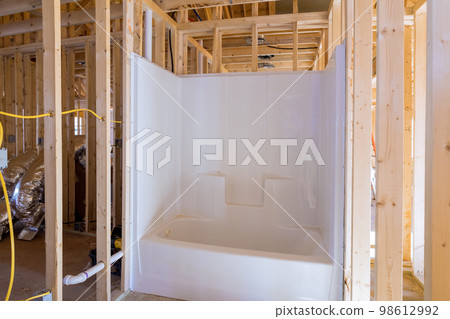 Unfinished bathroom under construction home with installed bathtub in new house Unfinished bathroom under construction home with installed bathtub in new house 98612992