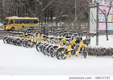 Yellow bicycle on snow-covered roadside Yellow bicycle on snow-covered roadside 98614707