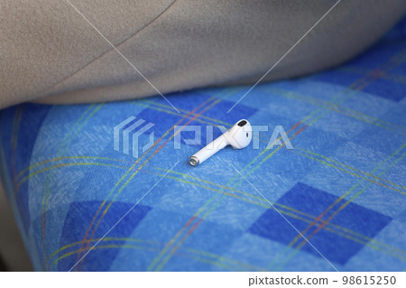 Image of a wireless earphone dropped on a train Image of a wireless earphone dropped on a train 98615250