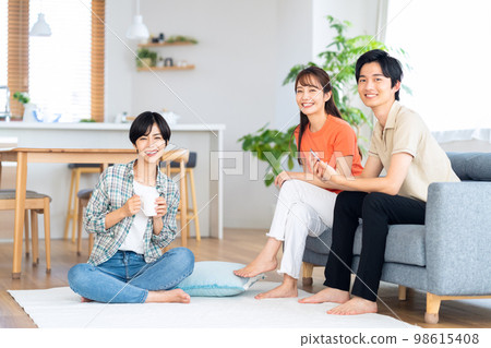 Friends men and women share house lifestyle living room 98615408