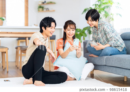 Friends men and women share house lifestyle living room 98615418