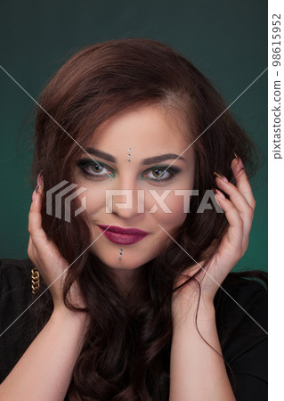Girl with green eye shadows, make-up, facial stones crystals Girl with green eye shadows, make-up, facial stones crystals 98615952