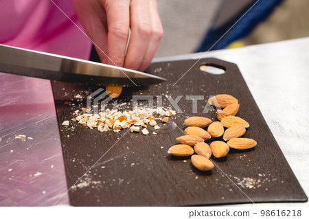 the cook cuts the nuts with a knife the cook cuts the nuts with a knife 98616218