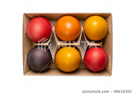 Multicolored Easter eggs, Paschal eggs, in a egg carton. Hard boiled, colorful dyed chicken eggs, used to celebrate the resurrection of Jesus during Eastertide. Symbol for fertility and rebirth. 98616305
