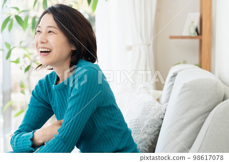 Middle woman relaxing on the sofa Middle woman relaxing on the sofa 98617078