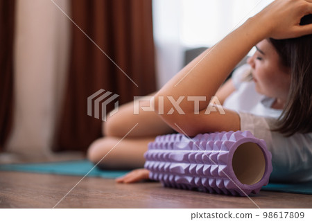 Lady gives herself a hand massage with a purple massage roller Lady gives herself a hand massage with a purple massage roller 98617809