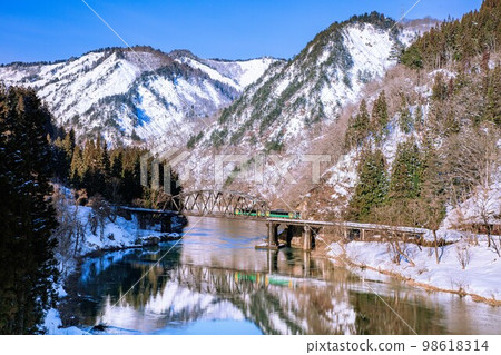 Tadami Line Kiha E120 series crossing the No. 4 Tadami River Bridge in winter (Kanayama Town, Fukushima Prefecture, January) 98618314