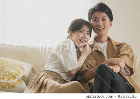 A couple of smiles sitting on the sofa A couple of smiles sitting on the sofa 98619186