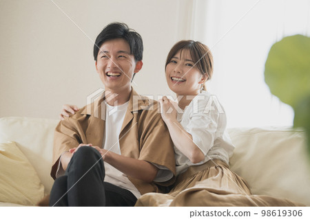 A couple of smiles sitting on the sofa A couple of smiles sitting on the sofa 98619306