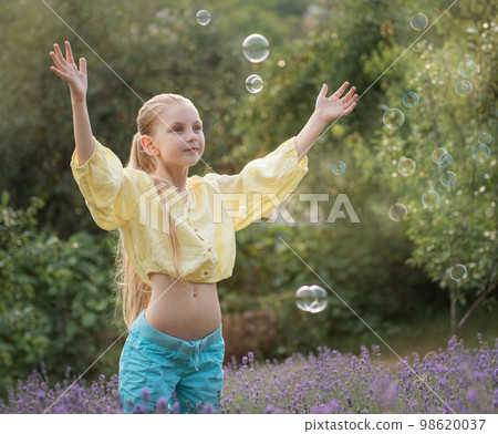 Beautiful little girl in a field with lavender. Beautiful little girl in a field with lavender. 98620037