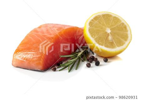 Salmon piece with rosemary, lemon, and peppercorn isolated on a white background. 98620931
