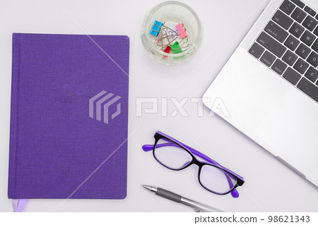 Office Supplies Over Desk With Keyboard And Glasses And Coffee Cup For Working Remotely, Assorted School Utilities For Studying With Hot Drink And Eyeglasses. 98621343