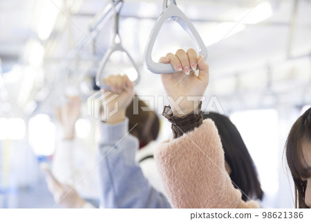 一名年輕女子的手緊握火車上的帶子 98621386