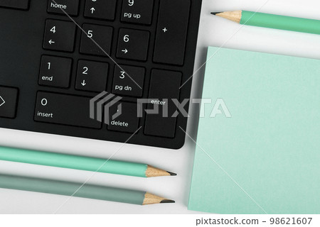 Colored paper with important message lying desk near keyboard. Main information written on notebook. School supplies. Multiple Assorted Collection Office Stationery. 98621607