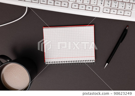 Coffee Cup Standing on Desk. Important infrormation written on paper. Different Office Supplies, Pencils, Pens, Marckers. Computer keyboard. Text on wood table. Coffee Cup Standing on Desk. Important infrormation written on paper. Different Office Supplies, Pencils, Pens, Marckers. Computer keyboard. Text on wood table. 98623249