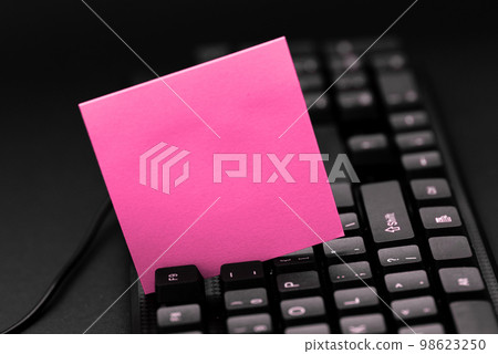Colored sticker lying on black keyboard. Important information written over paper. Image with school supplies. Multiple Assorted Collection Office Stationery. Colored sticker lying on black keyboard. Important information written over paper. Image with school supplies. Multiple Assorted Collection Office Stationery. 98623250
