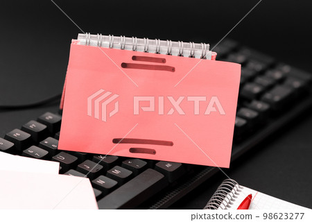 Colored sticker lying on black keyboard. Important information written over paper. Image with school supplies. Multiple Assorted Collection Office Stationery. Colored sticker lying on black keyboard. Important information written over paper. Image with school supplies. Multiple Assorted Collection Office Stationery. 98623277