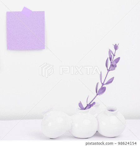 Pot with Plant and Coffee Cup Standing on White Desk. Important infrormation written on paper. Different Office Supplies, Pencils, Pens, Marckers. Computer keyboard. 98624154