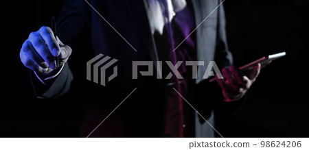 Man Holding Mobile Phone and Point On Recent Updates With Pen. Businessman Having Virtual Reality Eyeglasses, Cellphone And Presenting New Idea. Man Holding Mobile Phone and Point On Recent Updates With Pen. Businessman Having Virtual Reality Eyeglasses, Cellphone And Presenting New Idea. 98624206