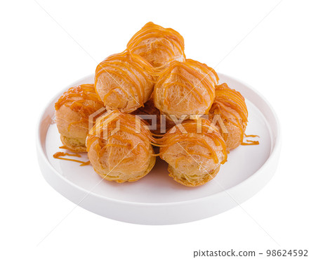 Tasty round eclairs with cream on white background Tasty round eclairs with cream on white background 98624592