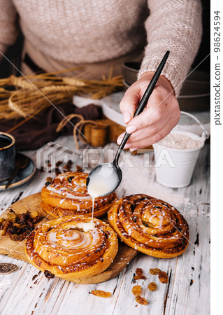 Homemade raisin roll pastry with vanilla icing Homemade raisin roll pastry with vanilla icing 98624594