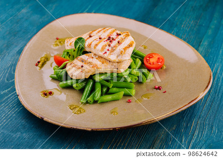 Grilled chicken fillets on green beans Grilled chicken fillets on green beans 98624642