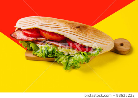 sandwich with sausage, ham and tomatoes 98625222