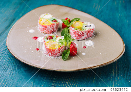 rolls of pink pancakes with different fruits and berries rolls of pink pancakes with different fruits and berries 98625452