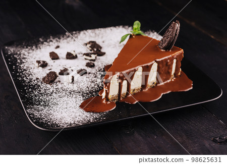 A piece of oreo cheesecake with chocolate cream A piece of oreo cheesecake with chocolate cream 98625631