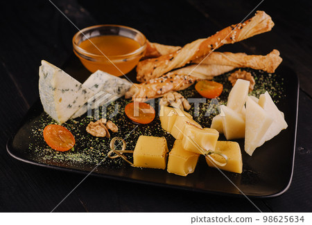 Cheese plate on black plate Cheese plate on black plate 98625634
