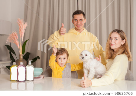 Parents in yellow clothes, mom and dad with child son and little white dog 98625766