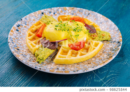 belgian waffles with poached egg and avocado 98625844