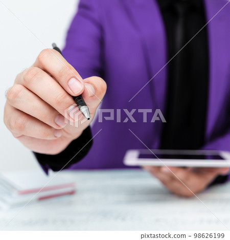 Man in Purple jacket sitting at white table And Pointing With Pen On Important Message. Holding mobile phone. Gentleman Showing Critical Announcement. Man in Purple jacket sitting at white table And Pointing With Pen On Important Message. Holding mobile phone. Gentleman Showing Critical Announcement. 98626199